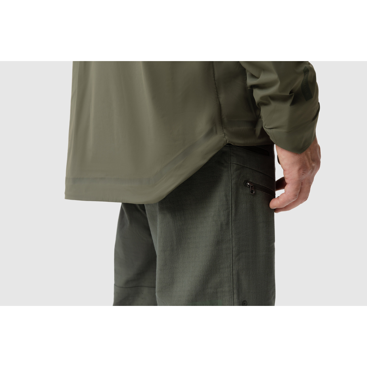 Side close-up photo of the Tomahawk Performance Crosswind Jacket's hem featuring the dropped back seat for coverage and wind protection.
